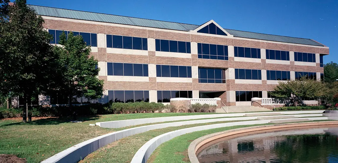 Modern Office Building With Circular Walkway, Plants, and Swimming Pool